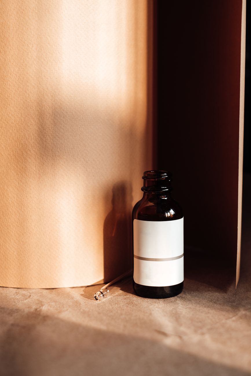 A single amber glass dropper bottle on a neutral background — the archival specimen of a single-active skincare formulation.