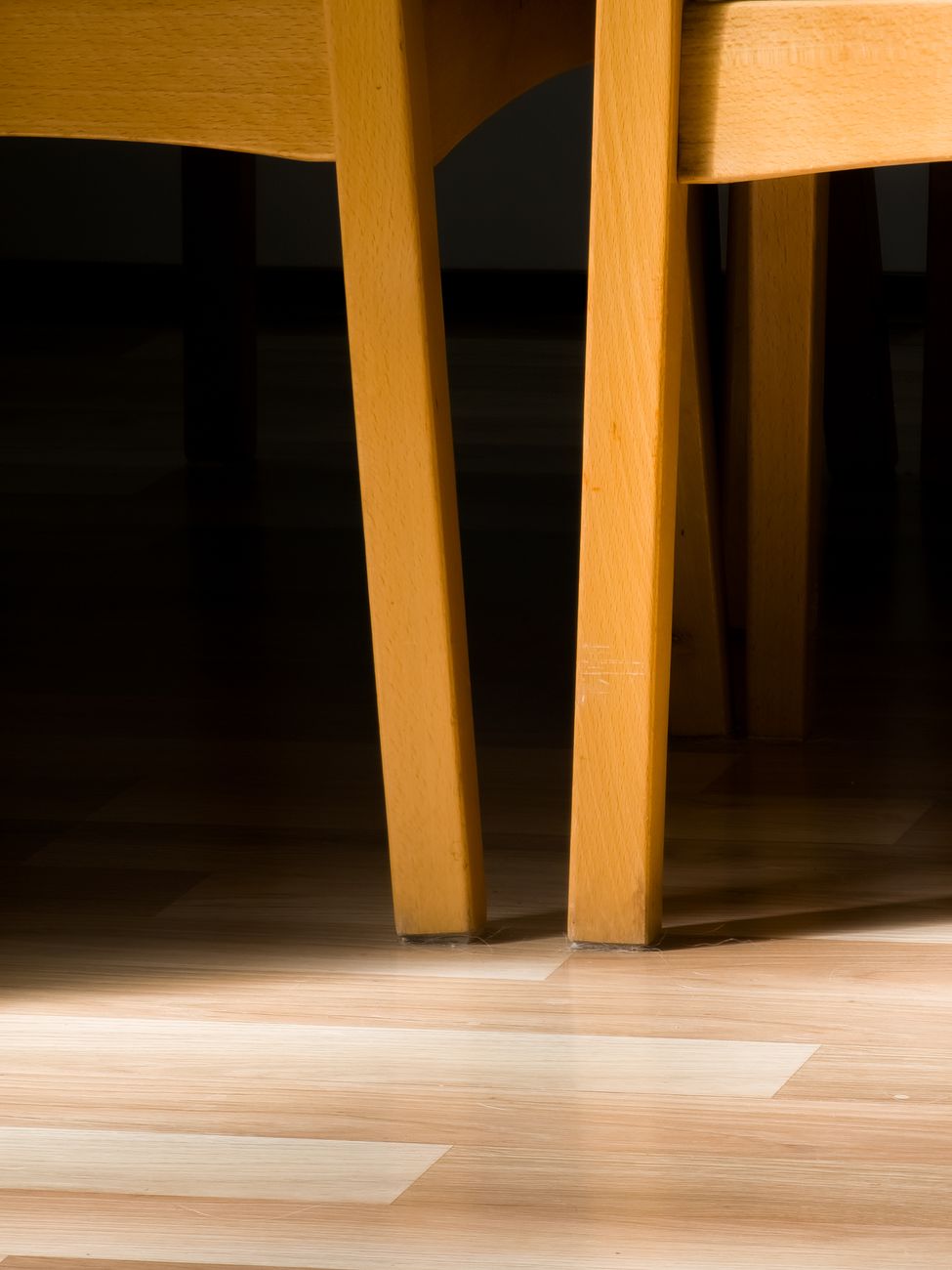 A close detail of a sofa's wooden leg and frame joint, showing solid construction.